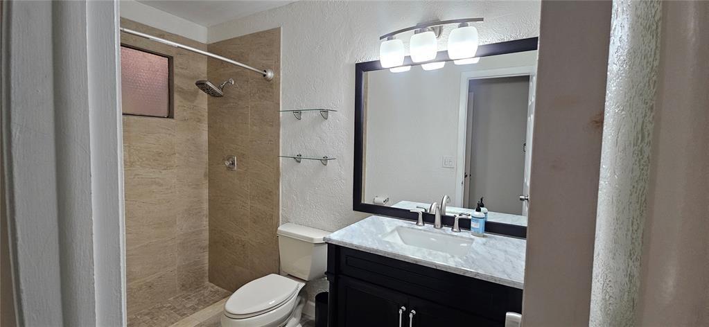814 Northwest 79th Terrace, Unit 814 Plantation, FL 33324 - Photo 14 of 21 a bathroom with a granite countertop sink toilet a mirror a vanity and shower