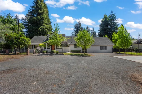 a front view of a house with a yard and tree s