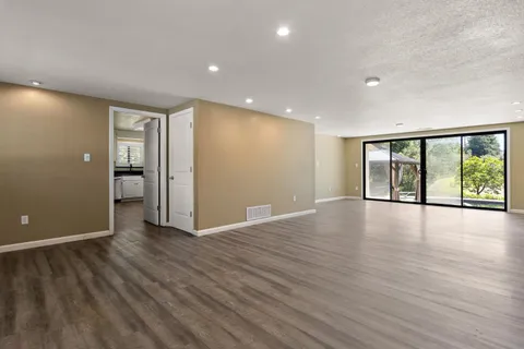 a view of a kitchen with wooden floor and windows