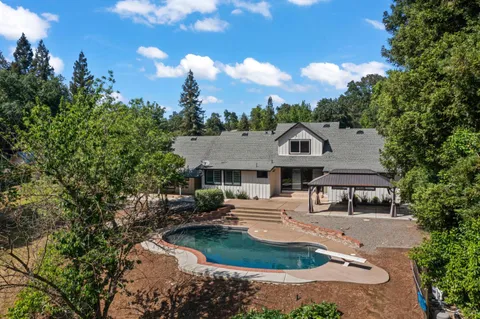 an aerial view of a house with yard and outdoor seating