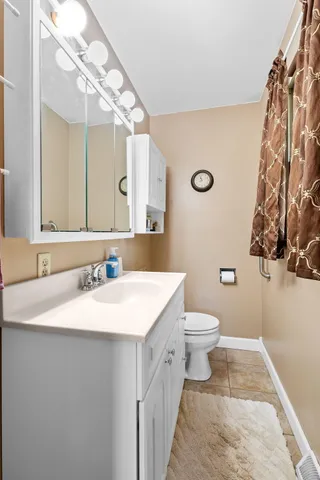 a bathroom with a sink a toilet and a mirror