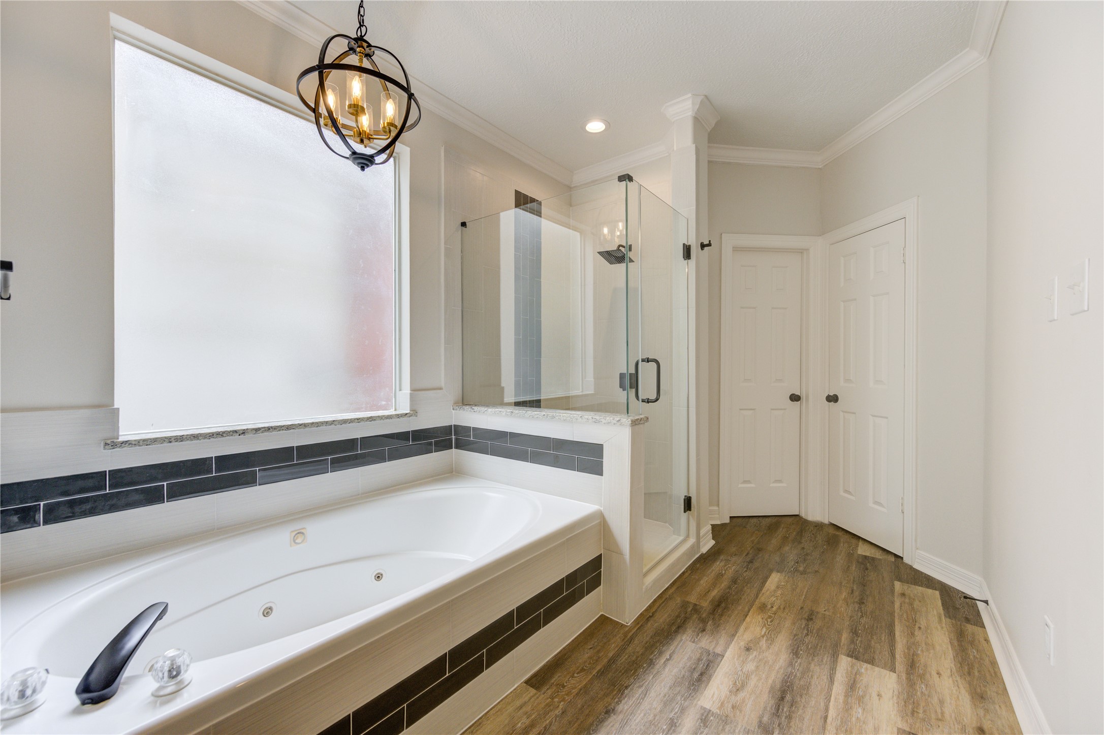 17318 Bonnard Circle Spring, TX 77379 - Photo 27 of 45 The chandelier adds the perfect ambiance for a relaxing bath. The tile surround and gray glass details are all brand new.