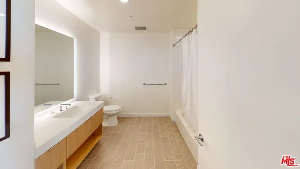 a bathroom with a double vanity sink toilet and shower