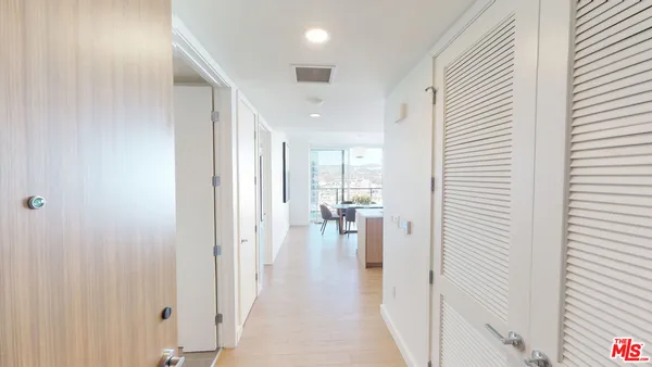 a view of a hallway with wooden floor windows and a livingroom with furniture