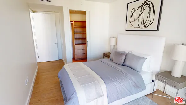 a bedroom with a bed and painting on the wall