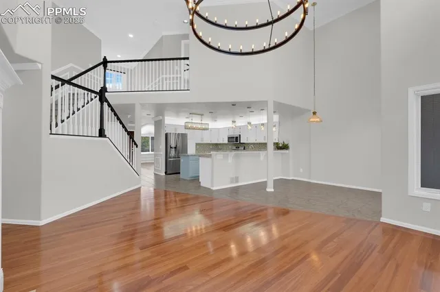 a view of a room with wooden floor and white cabinets