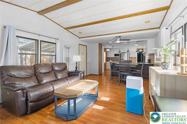 a living room with furniture wooden floor and kitchen view