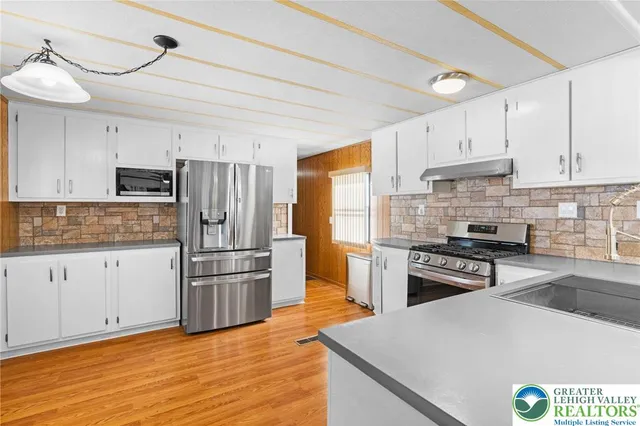 a kitchen with granite countertop a refrigerator stove and oven