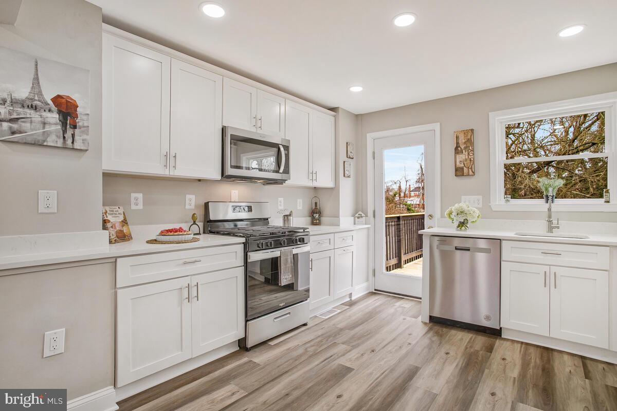 71 Del Rio Road Dundalk, MD 21222 - Photo 8 of 37 a kitchen with granite countertop white cabinets and white appliances