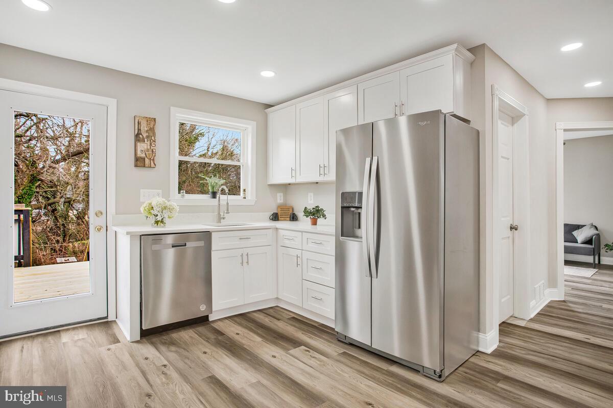 71 Del Rio Road Dundalk, MD 21222 - Photo 9 of 37 a kitchen with white cabinets and white appliances