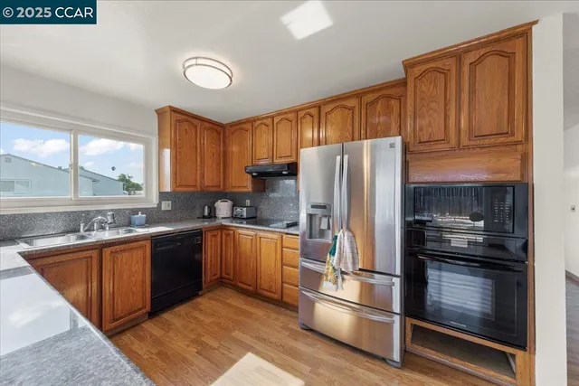 a kitchen with granite countertop stainless steel appliances and wooden cabinets