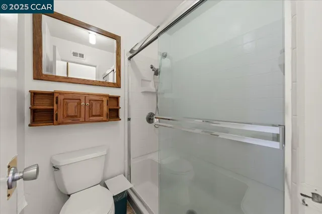 a bathroom with a toilet and a shower