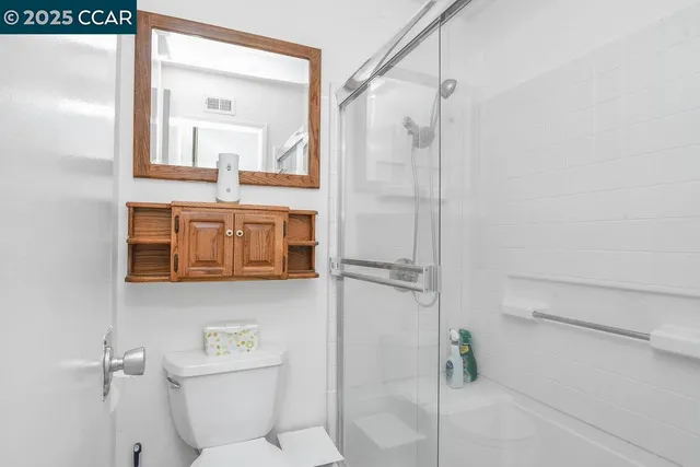 a bathroom with a shower a mirror and a sink