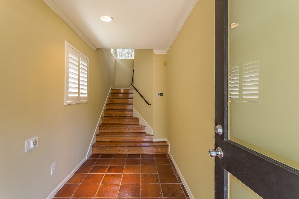 2349 Albans Road, Unit 2 Houston, TX 77005 - Photo 3 of 25 Step into a welcoming foyer bathed in natural light, featuring elegant terracotta tiles and a graceful wooden staircase that invites you to explore further.