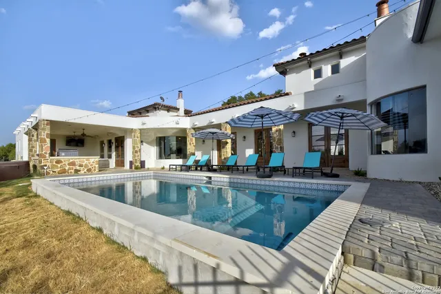 a view of a house with swimming pool and sitting area