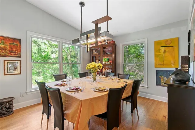 a dining room with furniture a chandelier and wooden floor