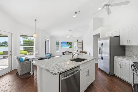 a kitchen with stainless steel appliances granite countertop a sink a stove and a refrigerator