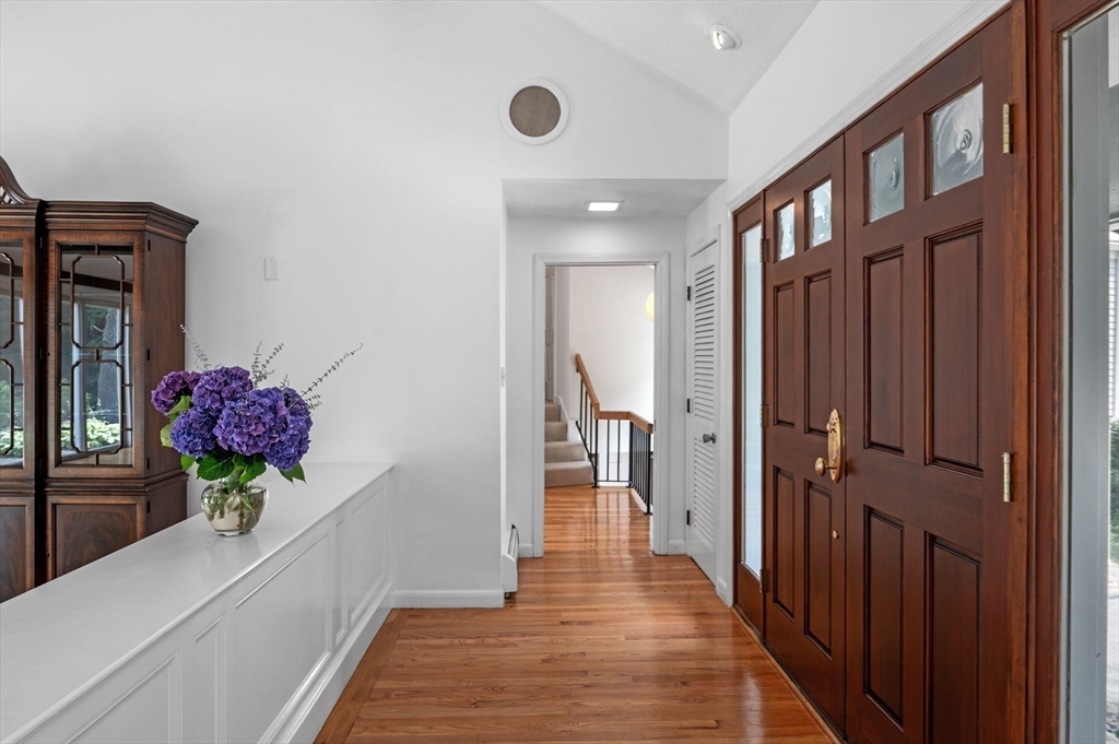 7 Ratlin Road Marblehead, MA 01945 - Photo 4 of 23 a hallway with wooden floor and a chandelier