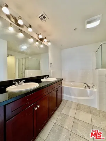 a spacious bathroom with a bathtub sink and mirror