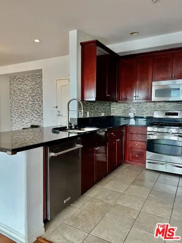 a kitchen with stainless steel appliances granite countertop a stove a sink and a microwave