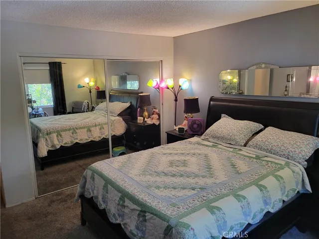 a bedroom with a bed a mirror and desk