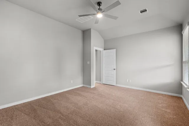 an empty room with a window and a fan
