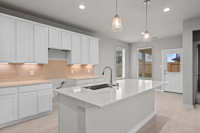 a large kitchen with kitchen island a sink stainless steel appliances and a fireplace