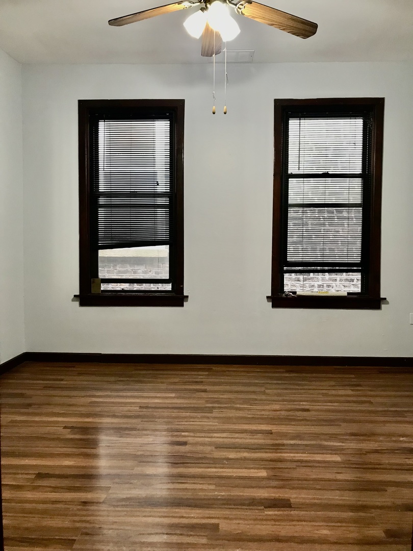 940 West 31st Place, Unit 2F Chicago, IL 60608 - Photo 5 of 10 an empty room with wooden floor and windows