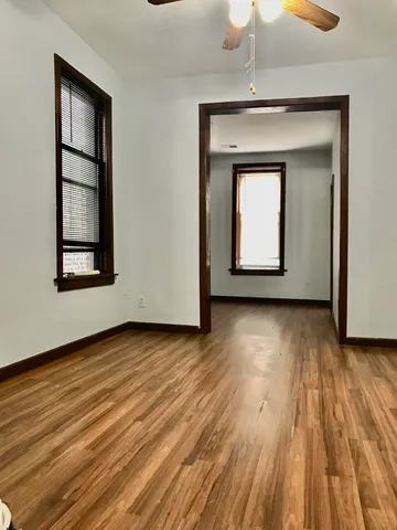 a view of a room with wooden floor and a window