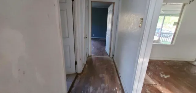 a view of a hallway with wooden floor and closet