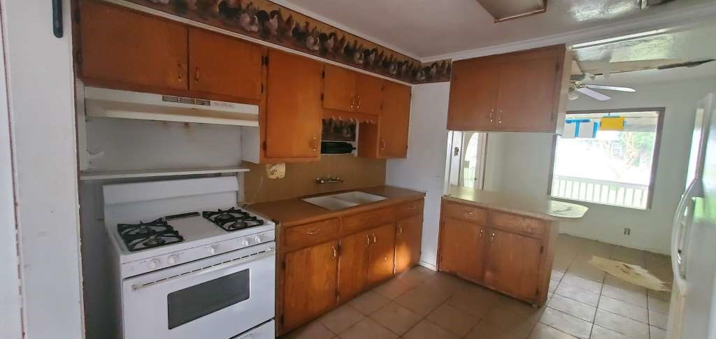 6136 25th Street Groves, TX 77619 - Photo 8 of 20 a kitchen with a stove and a refrigerator