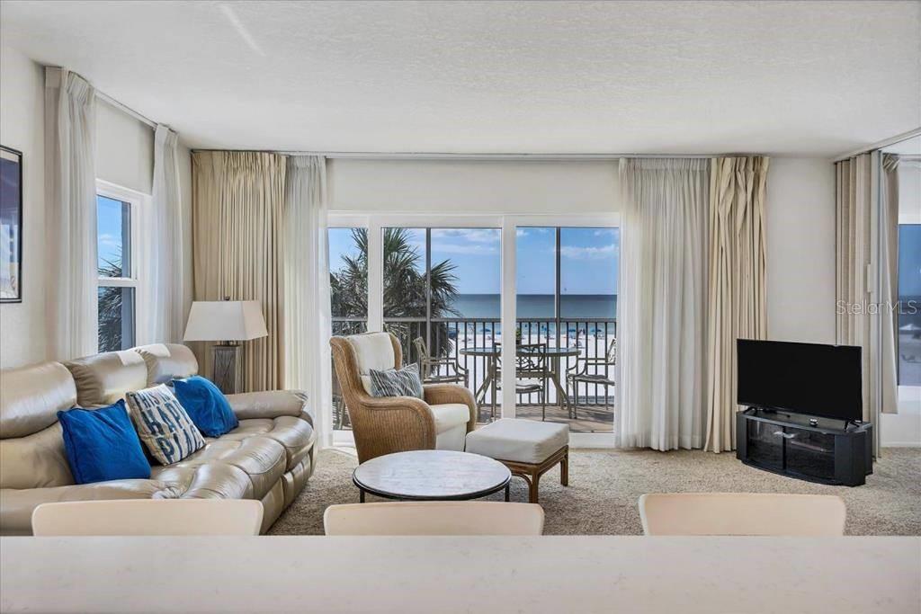 6154 Midnight Pass Road, Unit 301 Sarasota, FL 34242 - Photo 4 of 12 a living room with furniture and a flat screen tv