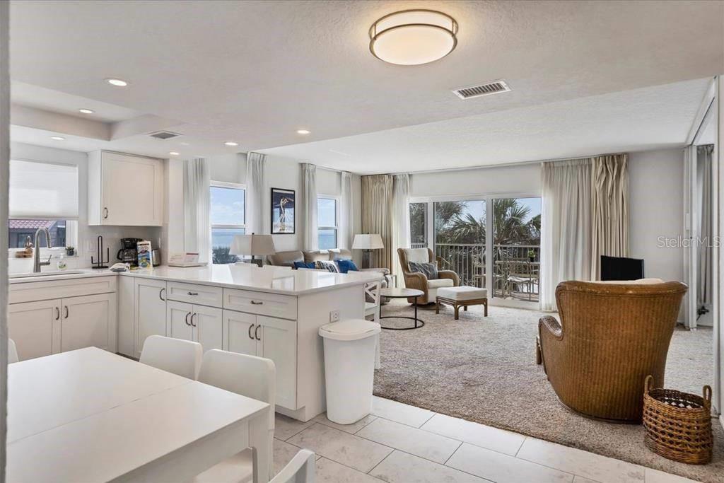 6154 Midnight Pass Road, Unit 301 Sarasota, FL 34242 - Photo 5 of 12 a kitchen with granite countertop sink table and chairs