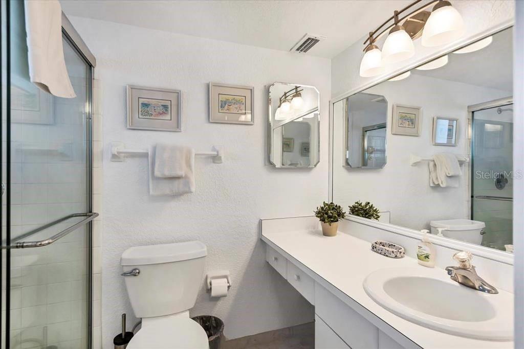 6154 Midnight Pass Road, Unit 301 Sarasota, FL 34242 - Photo 8 of 12 a bathroom with a sink toilet and mirror