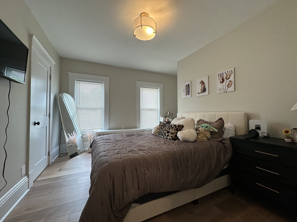 304 Main Street, Unit 2 Winthrop, MA 02152 - Photo 5 of 9 a bedroom with a bed and a lamp