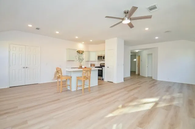 a view of a kitchen with wooden floor and a ceiling fan