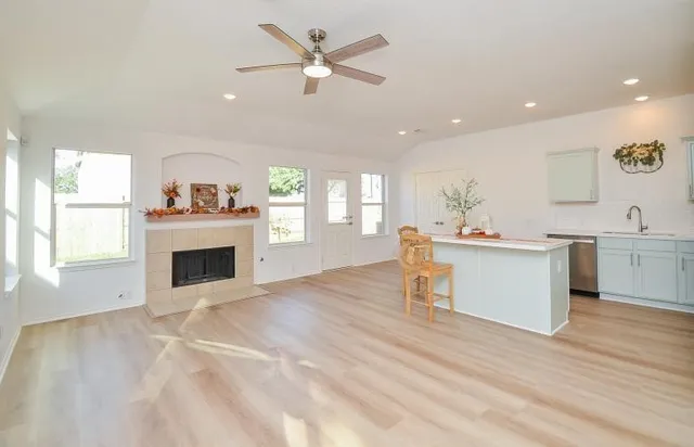 a view of a kitchen with furniture a fireplace and wooden floor