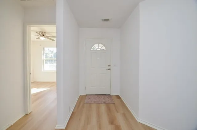 a view of empty room with wooden floor