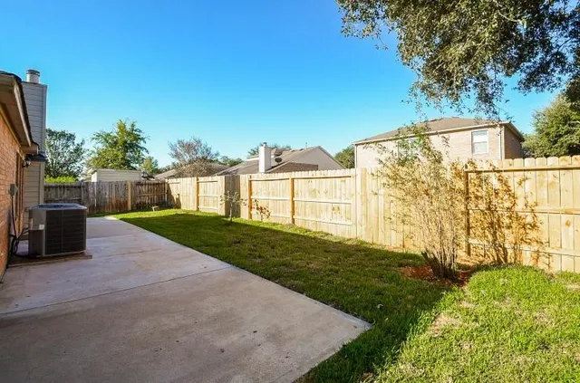 a view of an house with backyard and a tree