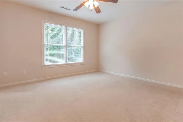 an empty room with a window and a fan