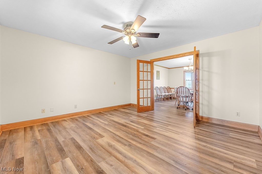 8690 Friendsville Road Lodi, OH 44254 - Photo 14 of 50 Spare room featuring ceiling fan with notable chandelier, light wood finished floors, and baseboards