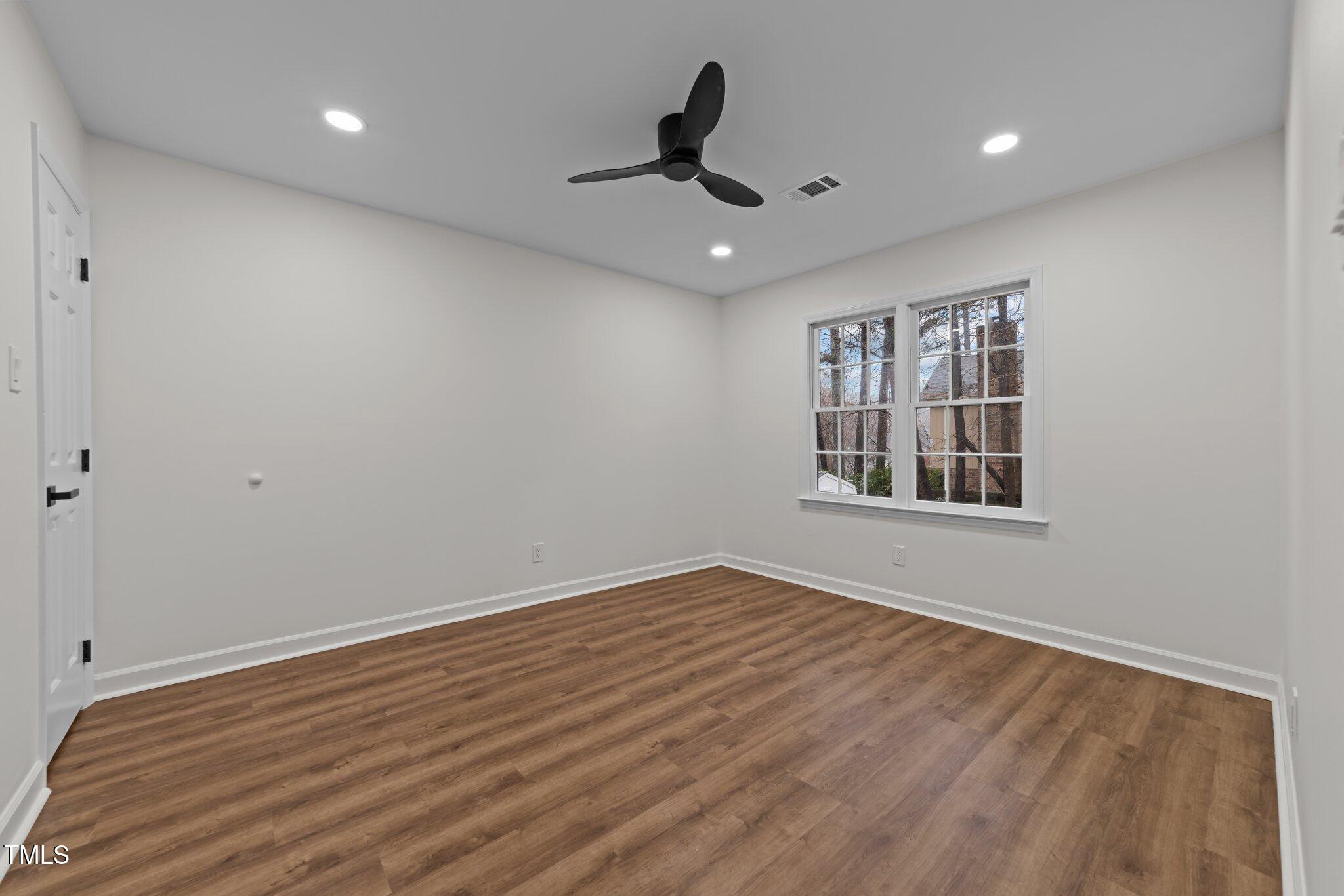 2001 Quail Ridge Road Raleigh, NC 27609 - Photo 17 of 40 a view of an empty room with a window and wooden floor