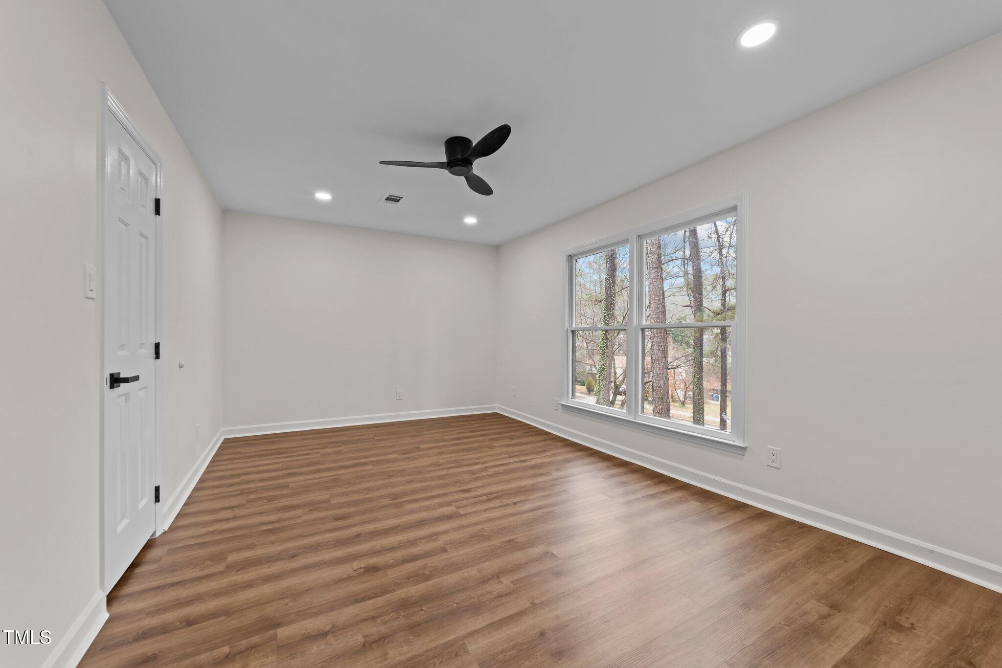 2001 Quail Ridge Road Raleigh, NC 27609 - Photo 26 of 40 a view of an empty room with wooden floor and a window