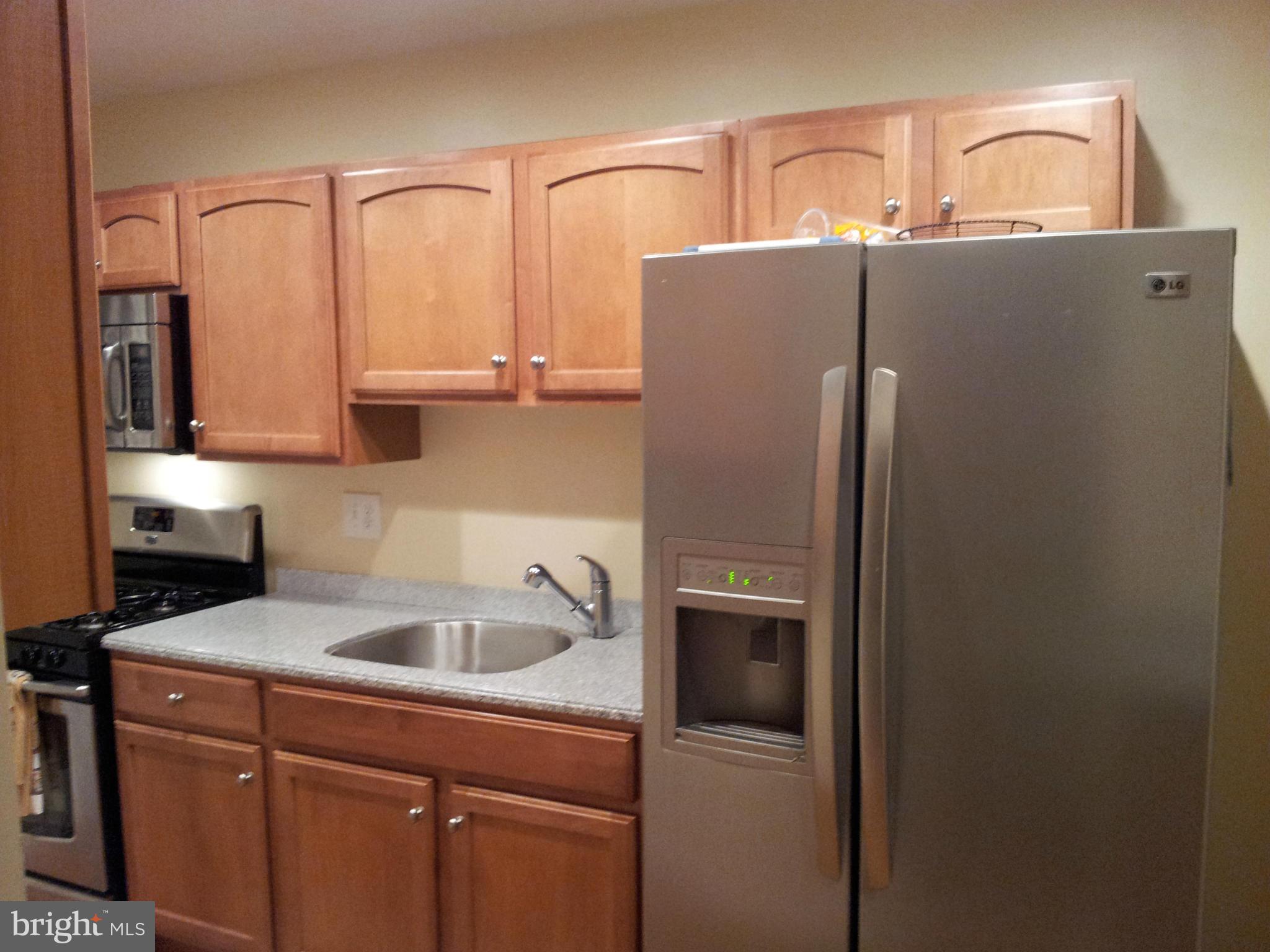 5815 Meridale Road Baltimore, MD 21228 - Photo 3 of 27 a kitchen with metallic refrigerator sink and cabinets