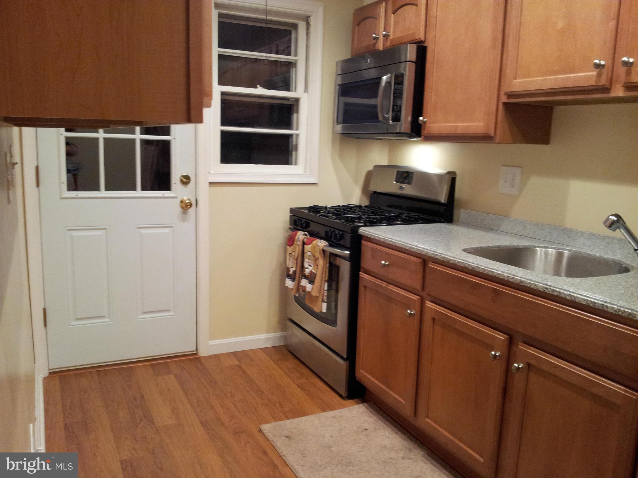 5815 Meridale Road Baltimore, MD 21228 - Photo 5 of 27 a kitchen with stainless steel appliances granite countertop a sink and a stove next to a window