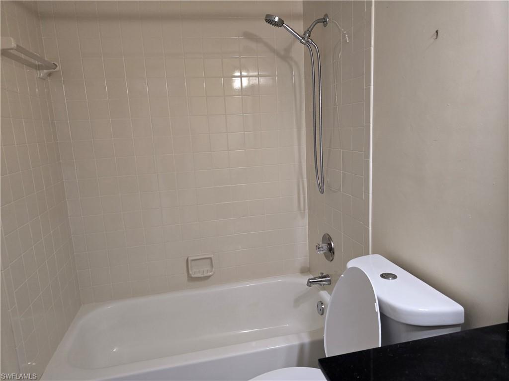 2660 Kings Lake Boulevard, Unit 7103 Naples, FL 34112 - Photo 11 of 22 a bathroom with a bathtub and shower