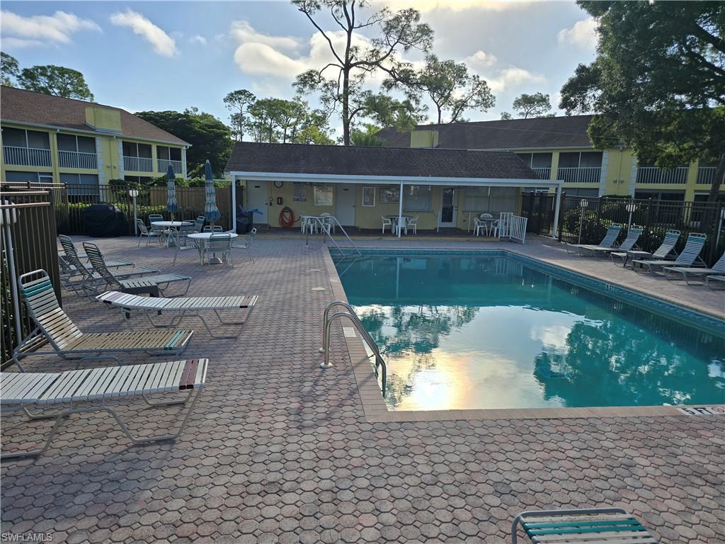 2660 Kings Lake Boulevard, Unit 7103 Naples, FL 34112 - Photo 18 of 22 a view of house with swimming pool and furniture
