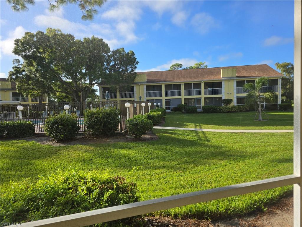 2660 Kings Lake Boulevard, Unit 7103 Naples, FL 34112 - Photo 20 of 22 a front view of a house with a yard table and chairs