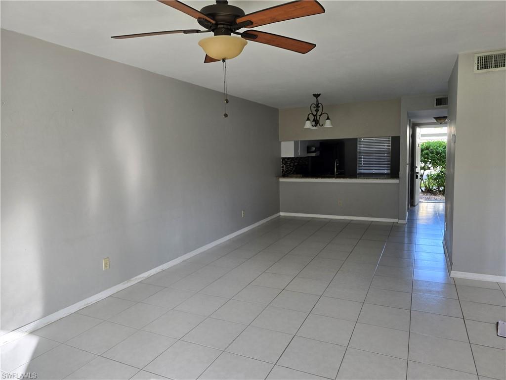 2660 Kings Lake Boulevard, Unit 7103 Naples, FL 34112 - Photo 4 of 22 an empty room with a ceiling fan and a window