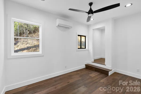 a view of room with window and wooden floor